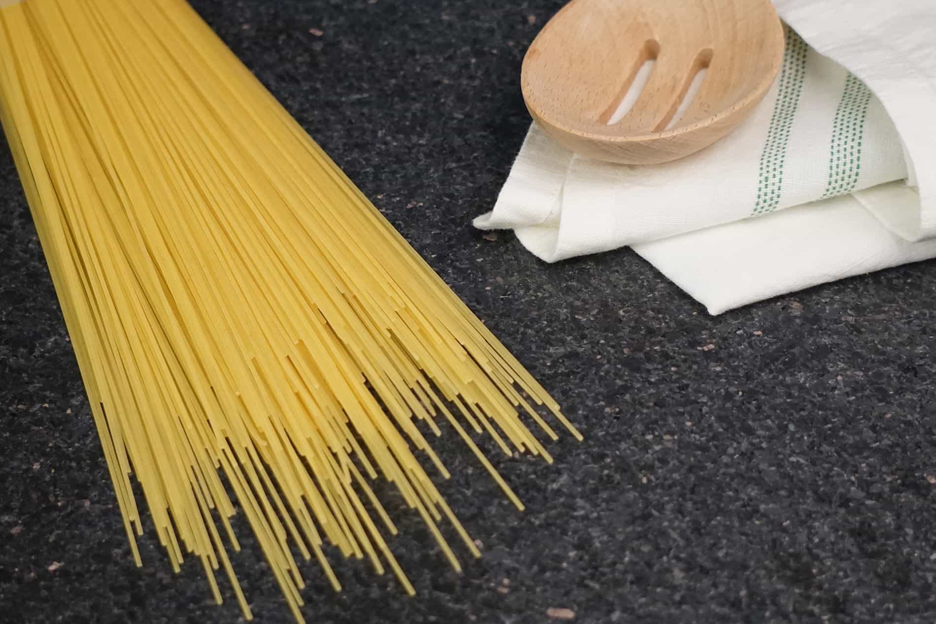 Espagueti seco sobre una mesa de cocina oscura